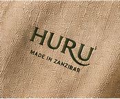 HURU Made in Zanzibar mark printed in green on natural textured linen